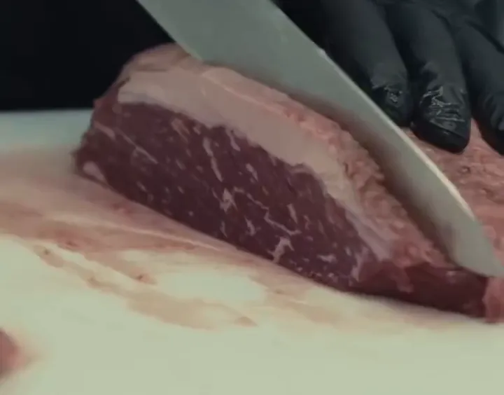 Picanha sendo cortada na hora no balcão do açougue