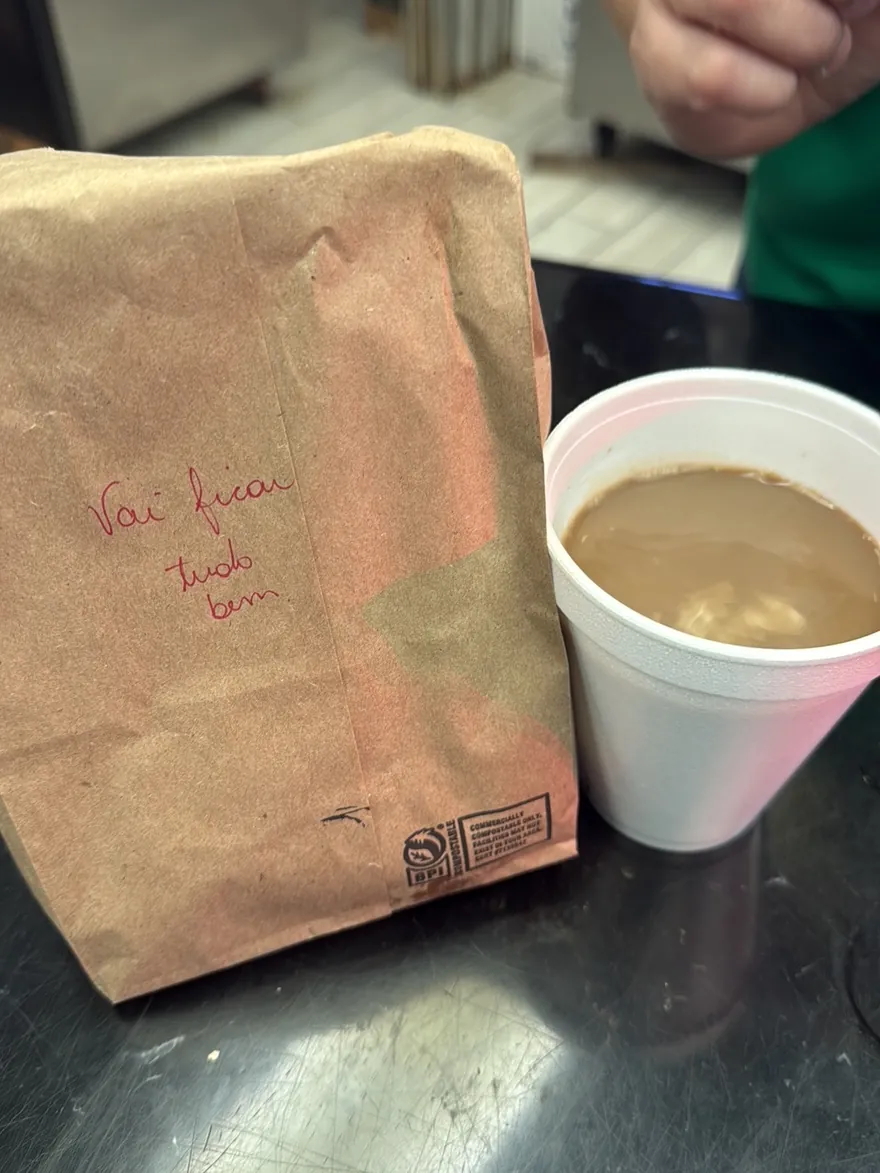 Cafezinho no copo e o pão na sacola