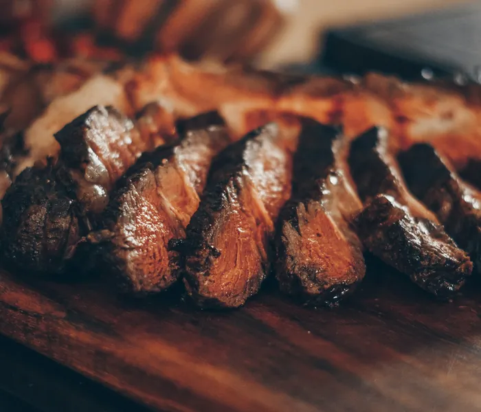 Picanha fatiada saindo da brasa