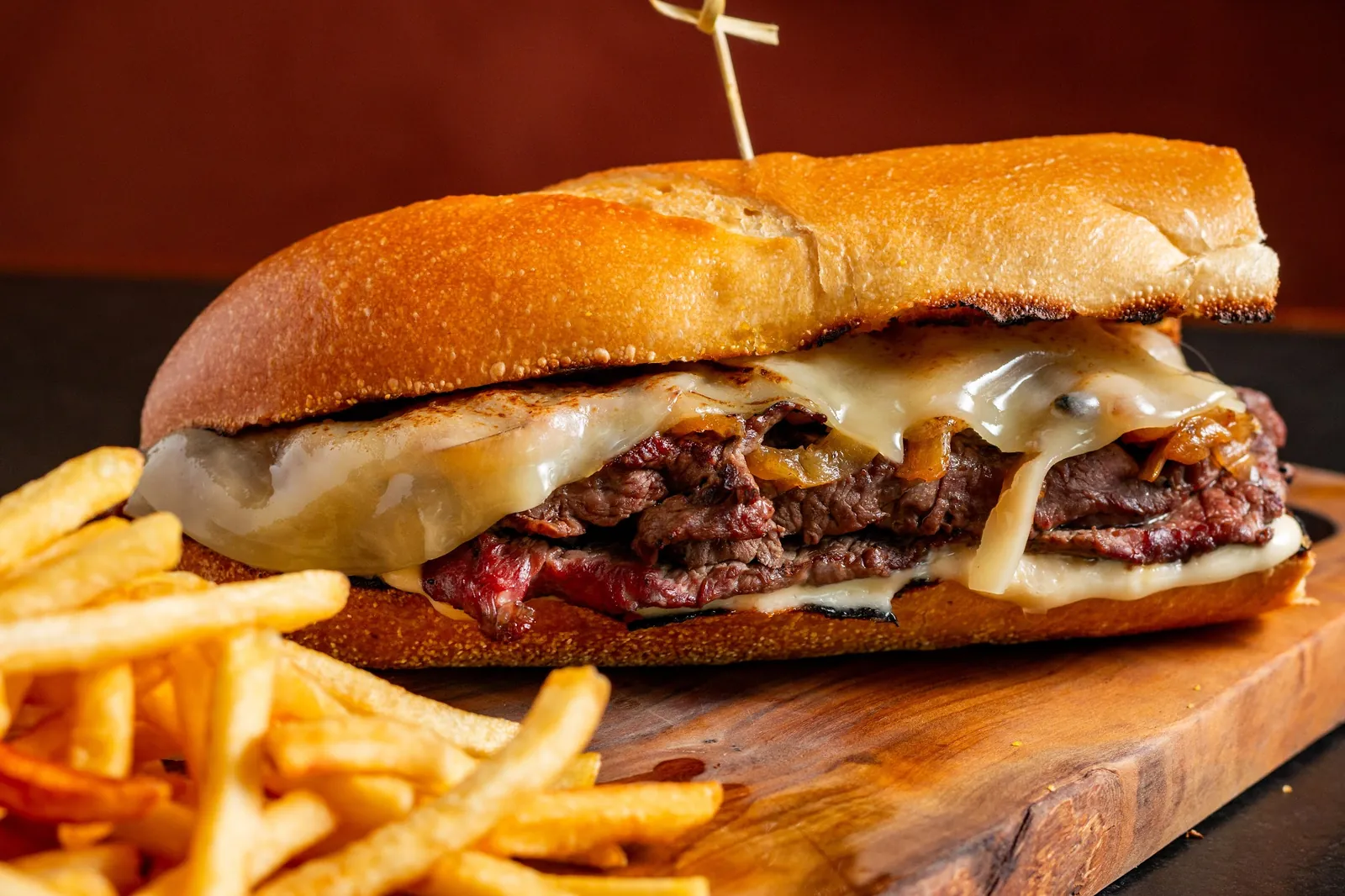 Braza Steak Sandwich with fries on a wooden board