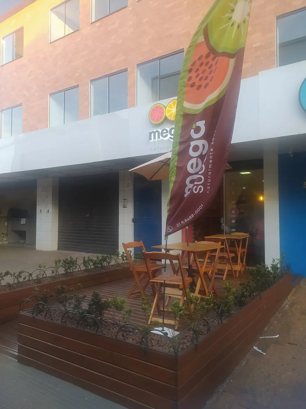 Fachada da Mega Suco com o deck de madeira e a bandeira de melancia