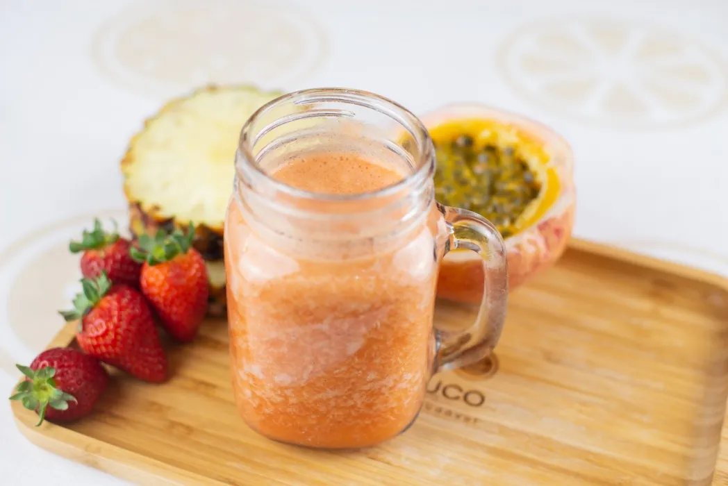 Três potes de suco natural, de laranja, mamão e morango