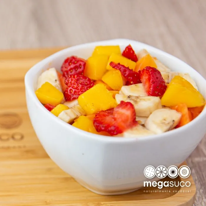 Salada de frutas com manga, morango e banana numa tigela branca