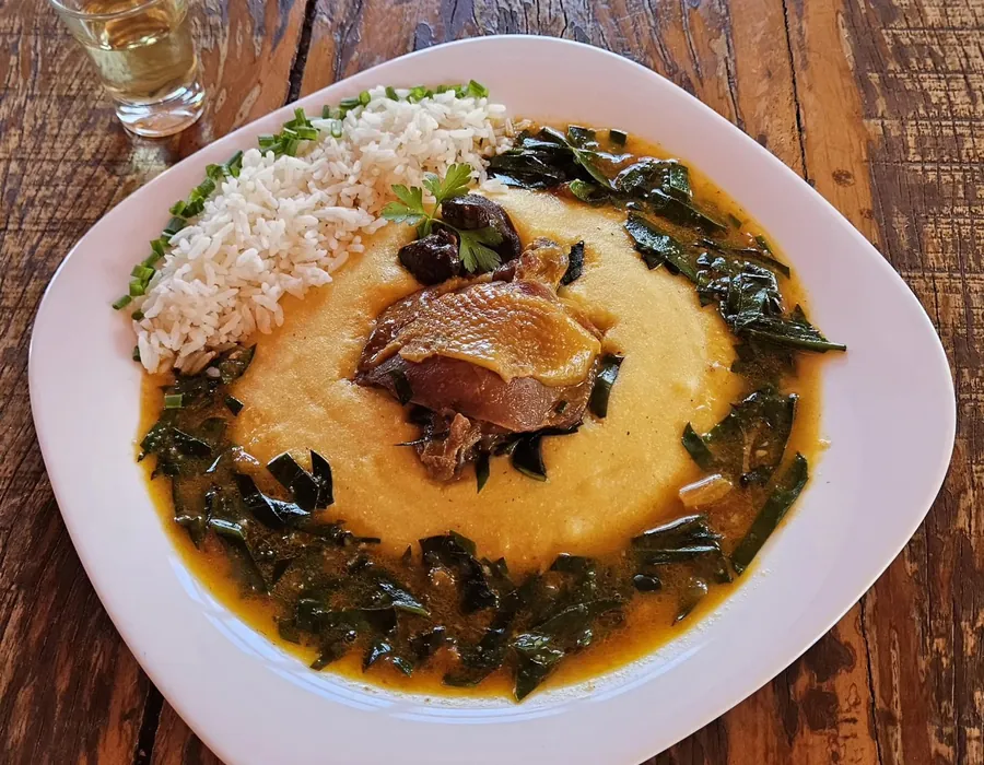 Frango caipira com ora-pro-nóbis e angu, servido no restaurante da pousada