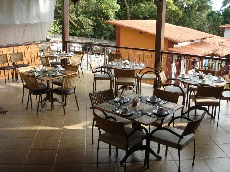 O salão do restaurante, com as mesas postas e o jardim do lado de fora