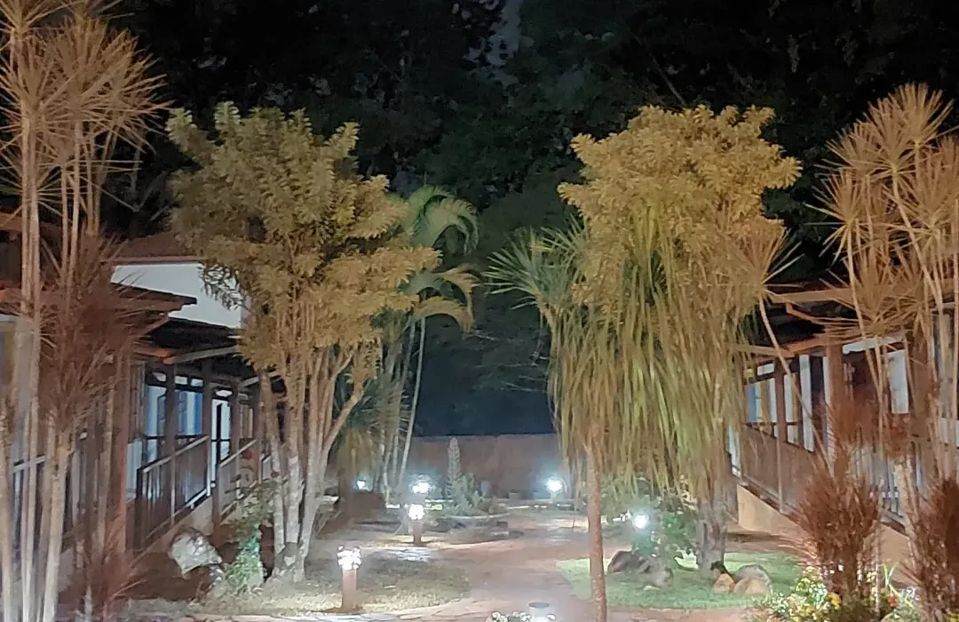 O jardim da pousada à noite, com os caminhos iluminados entre os quartos