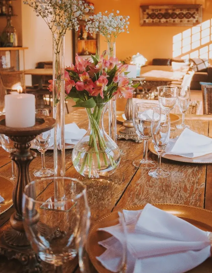 Mesa posta com flores e taças no salão