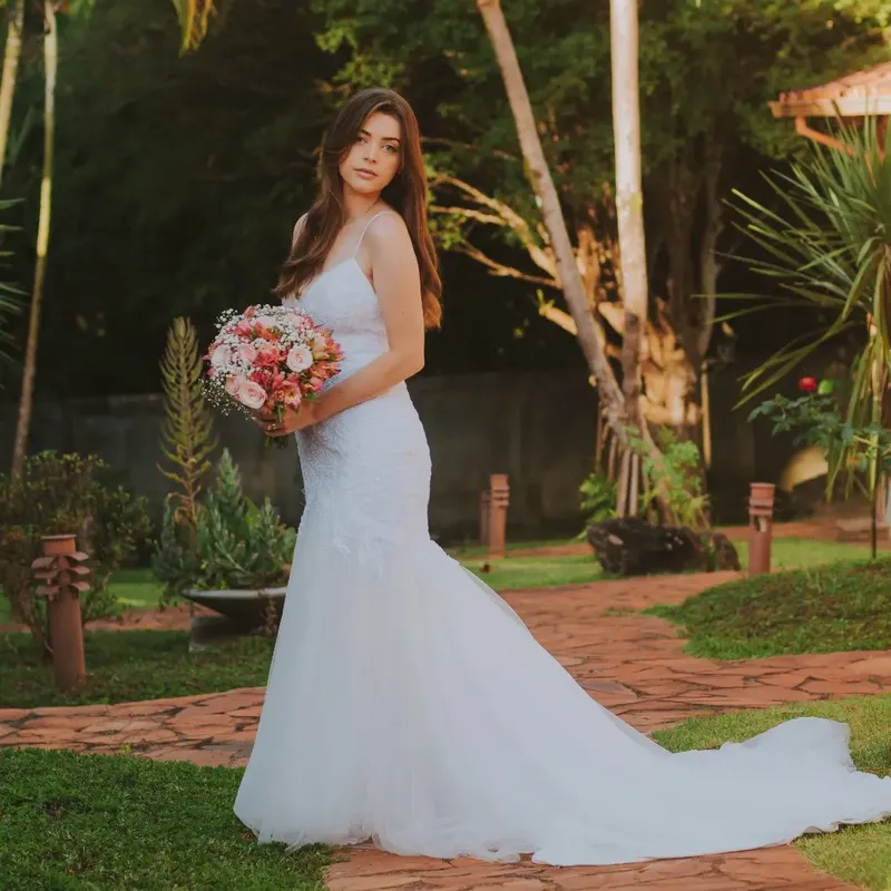 Noiva com buquê no jardim da pousada
