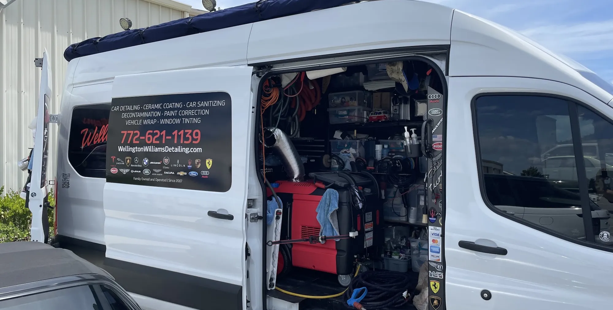 Wellington's white Ford Transit van parked with the side door open, steamer and detailing supplies inside, the phone number 772-621-1139 on the door