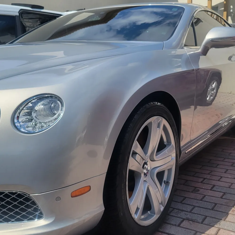 Silver Bentley Continental on a brick driveway